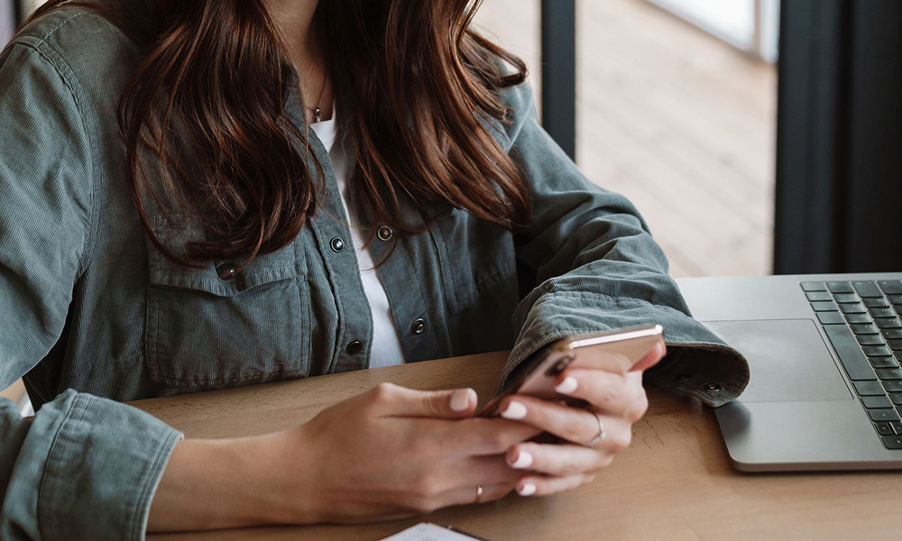 Imagem com mulher utiizando o celular